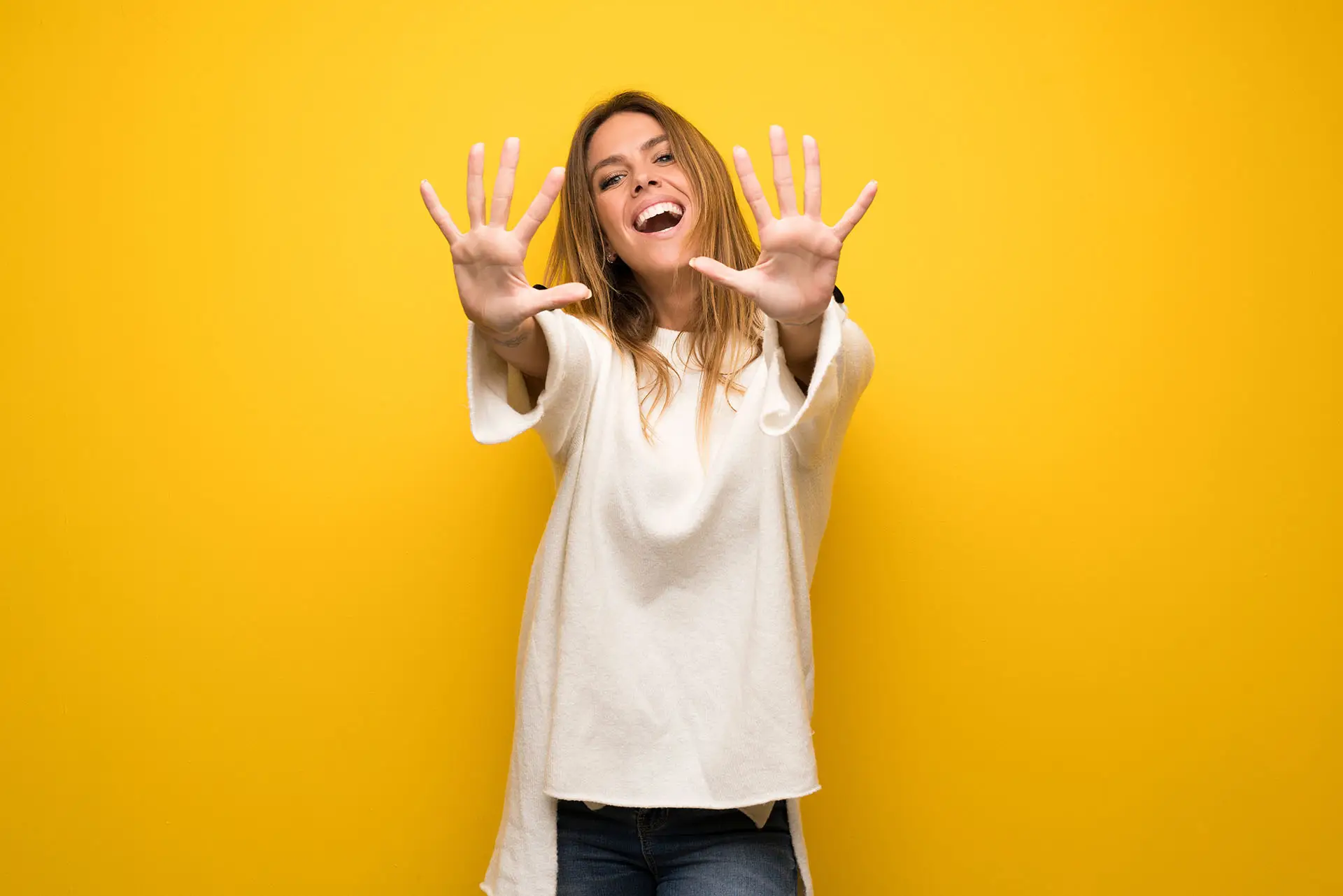 10 Free and Low Cost Online Tools for Small Business image shows a vibrant yellow background with a casually dressed lady holding up all 10 fingers