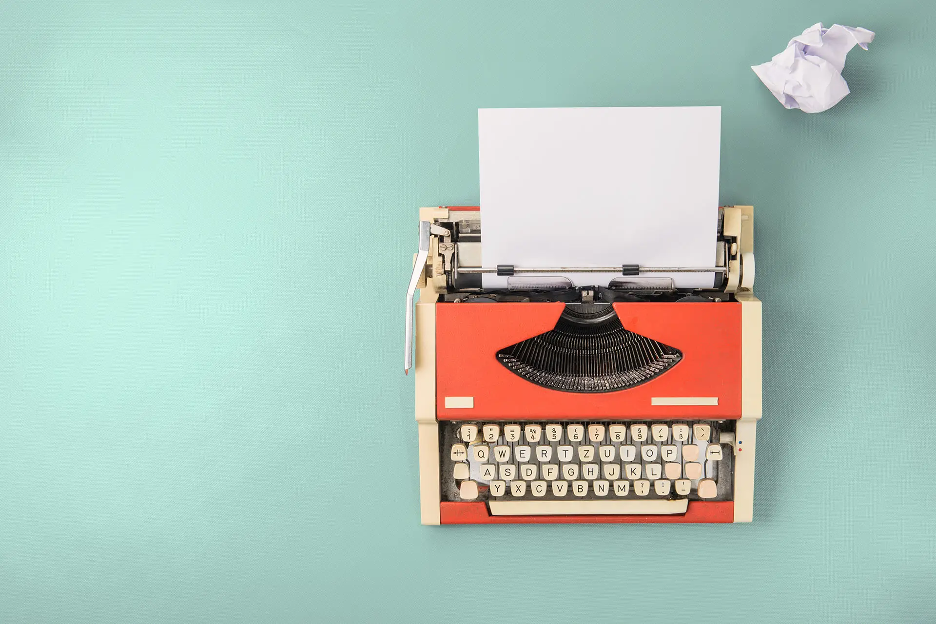 Blog Basics images shows an old orange typewriter with a scrunched up piece of paper next to it - blog writing concept