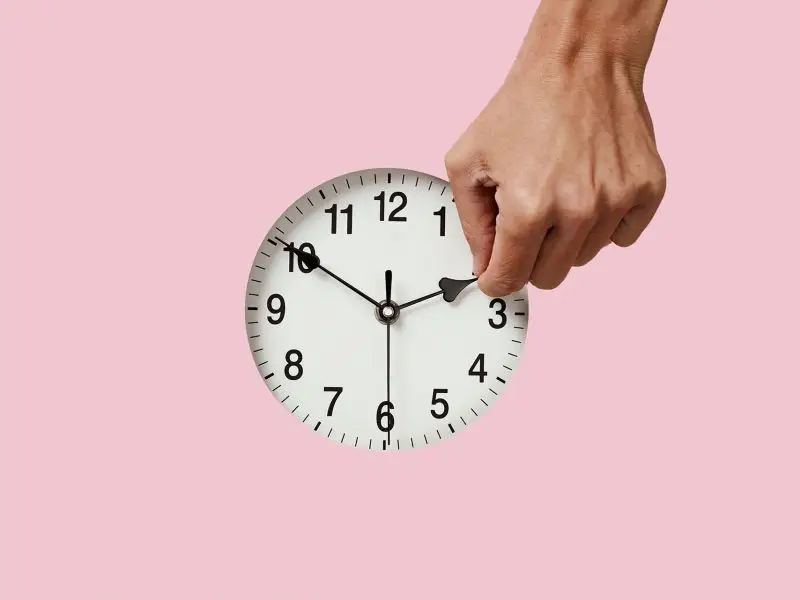 Facebook Moves Time, this image shows a pink background with a clock and a hand moving time