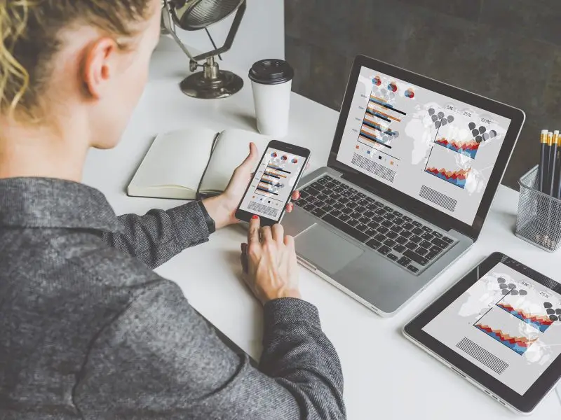 Google Analytics Update 2013 image shows a lady accessing google analytics data on her laptop, mobile and tablet.