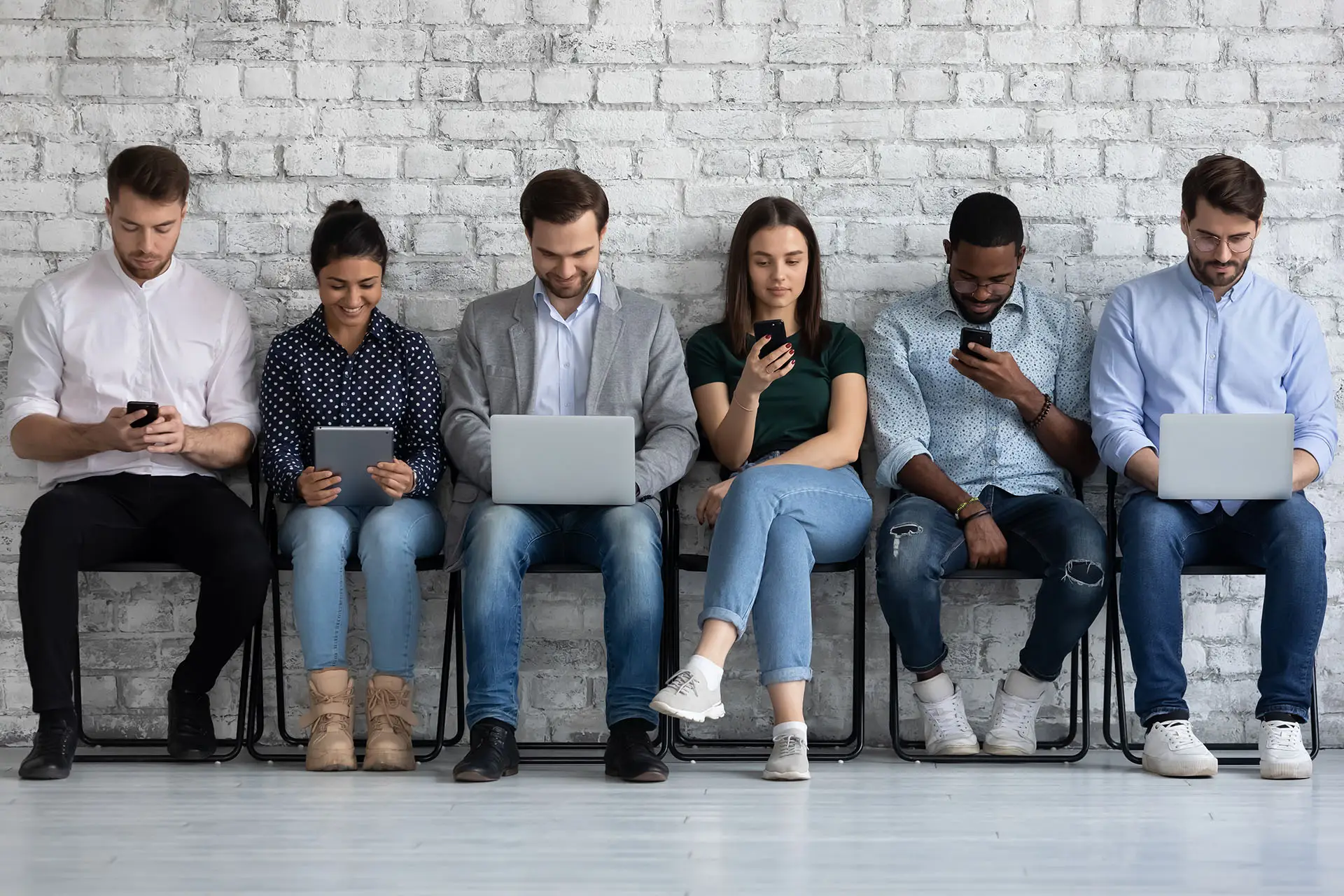 Google+ Demographics the images shows a range of people all sitting on chairs engrossed in their phones or laptops