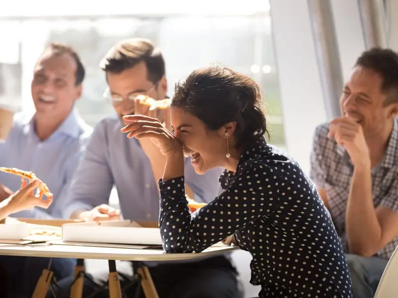 How to Get the Best From Your Sales Team. This image shows a sales team eating pizza and laughing