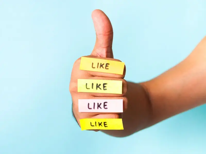 So, You’ve Got the Magic 25 Facebook Likes… Now What? The image shows a human thumbs up with mini post it notes with the word Like written placed on each finger