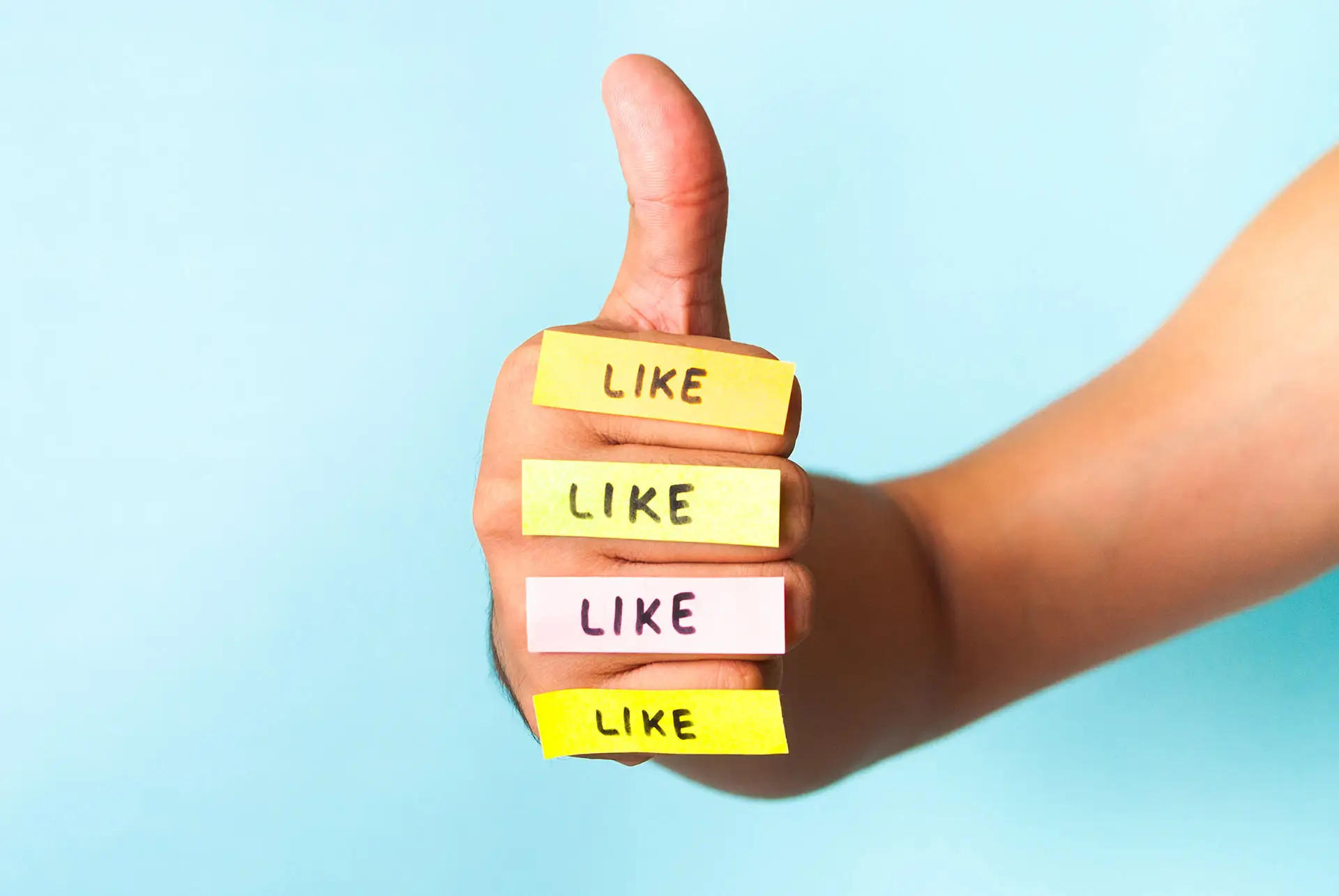 So, You’ve Got the Magic 25 Facebook Likes… Now What? The image shows a human thumbs up with mini post it notes with the word Like written placed on each finger