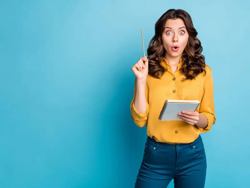 Social Media Marketing Top Tips this image shows a lady with a pad and pen, with the pen raised and a facial expression that seems to say "ahah" - concept image for top tips