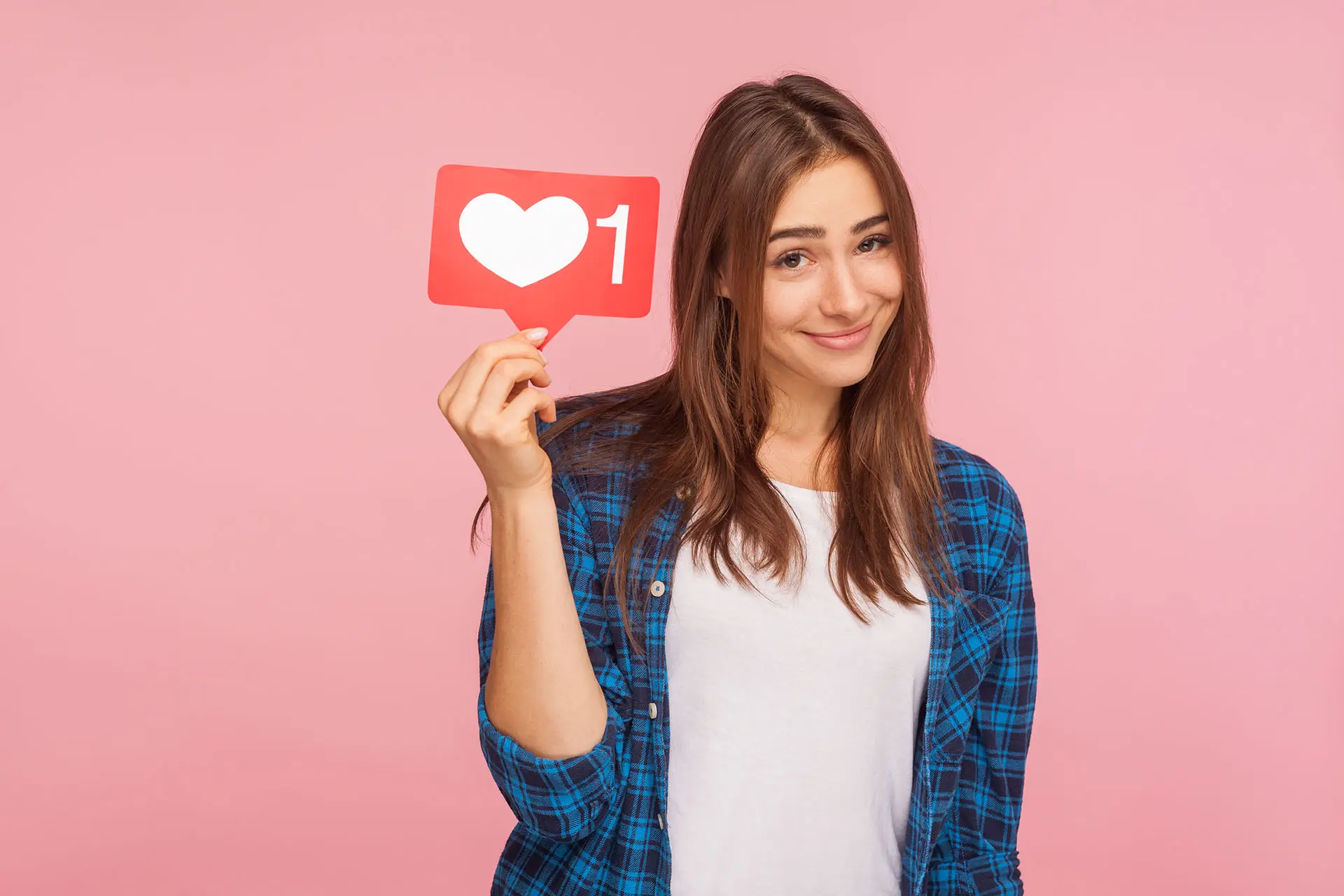 Social Media Marketing in 2013 this image shows a lady dressed in a blue checked shirt holding up a red speech bubble with a heart and number 1 in it - social media concept