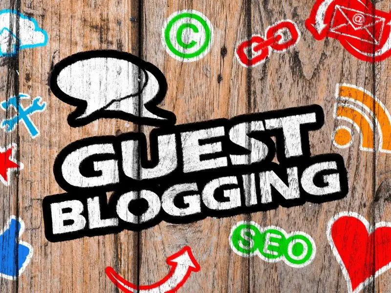 The Rise and Fall of the Guest Blog the graphic shows a wooden background with guest blogging featured in the centre surrounded action and social icons