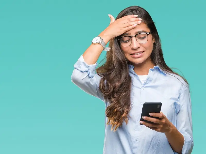 Understanding Features and Benefits the image shows a lady looking at her phone with her hand on her forehead looking worried - concept understaing the difference between features and benefits