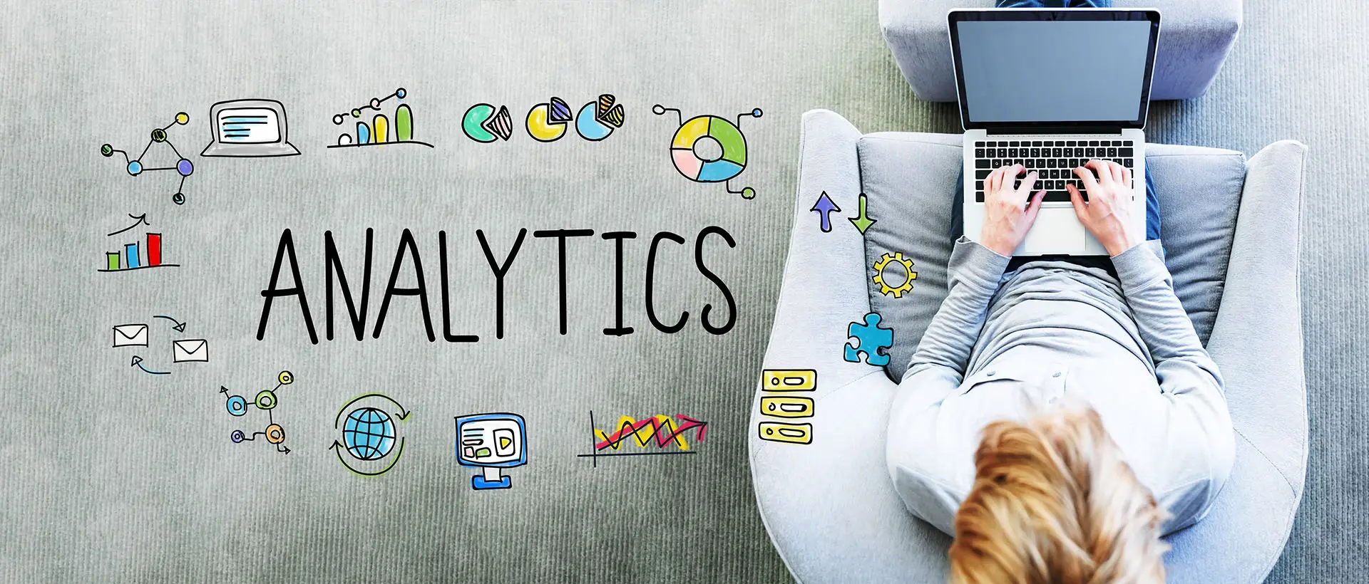 Understanding Google Analytics - Terms and Definitions. This image shows a person sitting in a chair working on their laptop with the word analytics and various icons next to them - Google analytics concept