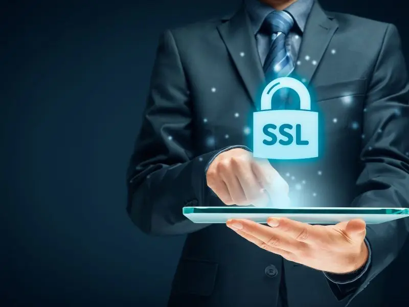 What is an SSL and Why do I Need One? This image shows a man holding a tablet with a padlock with SSL written on emitting from the tablet