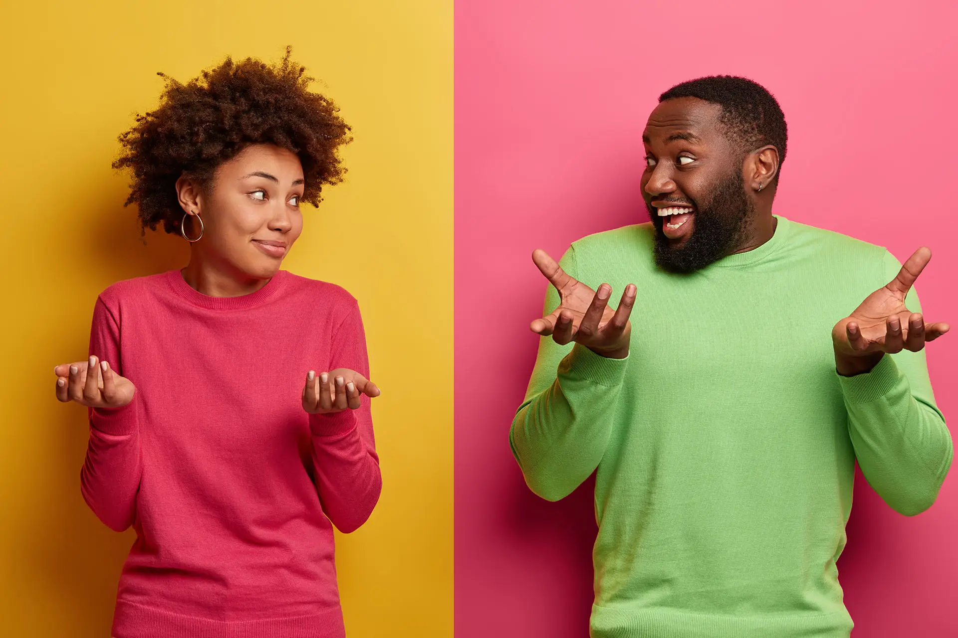 What to Blog About this image is a split screen a lady in a pink jumper with a yellow background on the left and a man in a green jumper and a pink background of the right, they are looking at each other with their arms raised in a shrug - what to write about concept