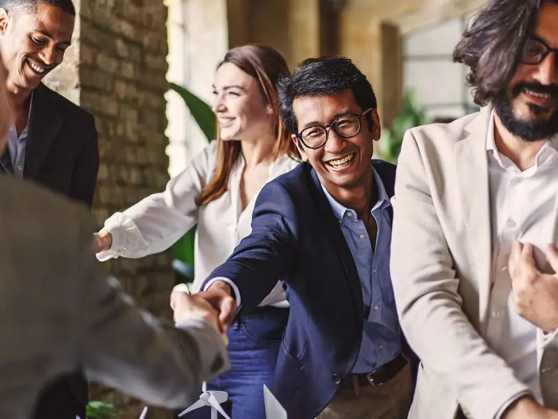 10 Benefits of Joining a Networking Group - this image shows a variety of business professionals, shaking hands, smiling and chatting