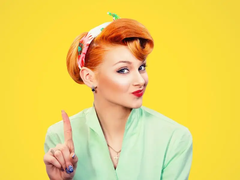 Is The Customer Always Right? This image shows a bright yellow background with an attractive lady in the foreground with her finger raised as if to rebuttal a point