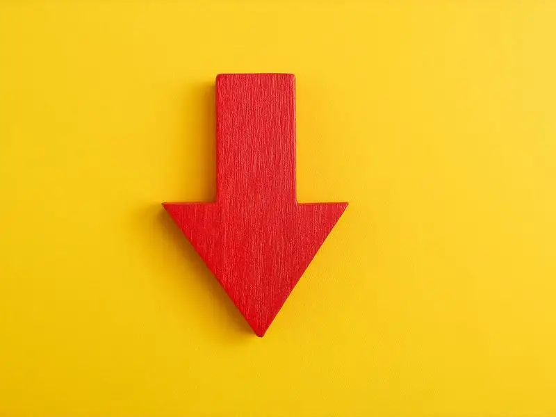 Loss Leaders and Small Businesses Don't Mix this image shows a bright yellow background with a wooden bright red arrow pointing down - loss leader concept