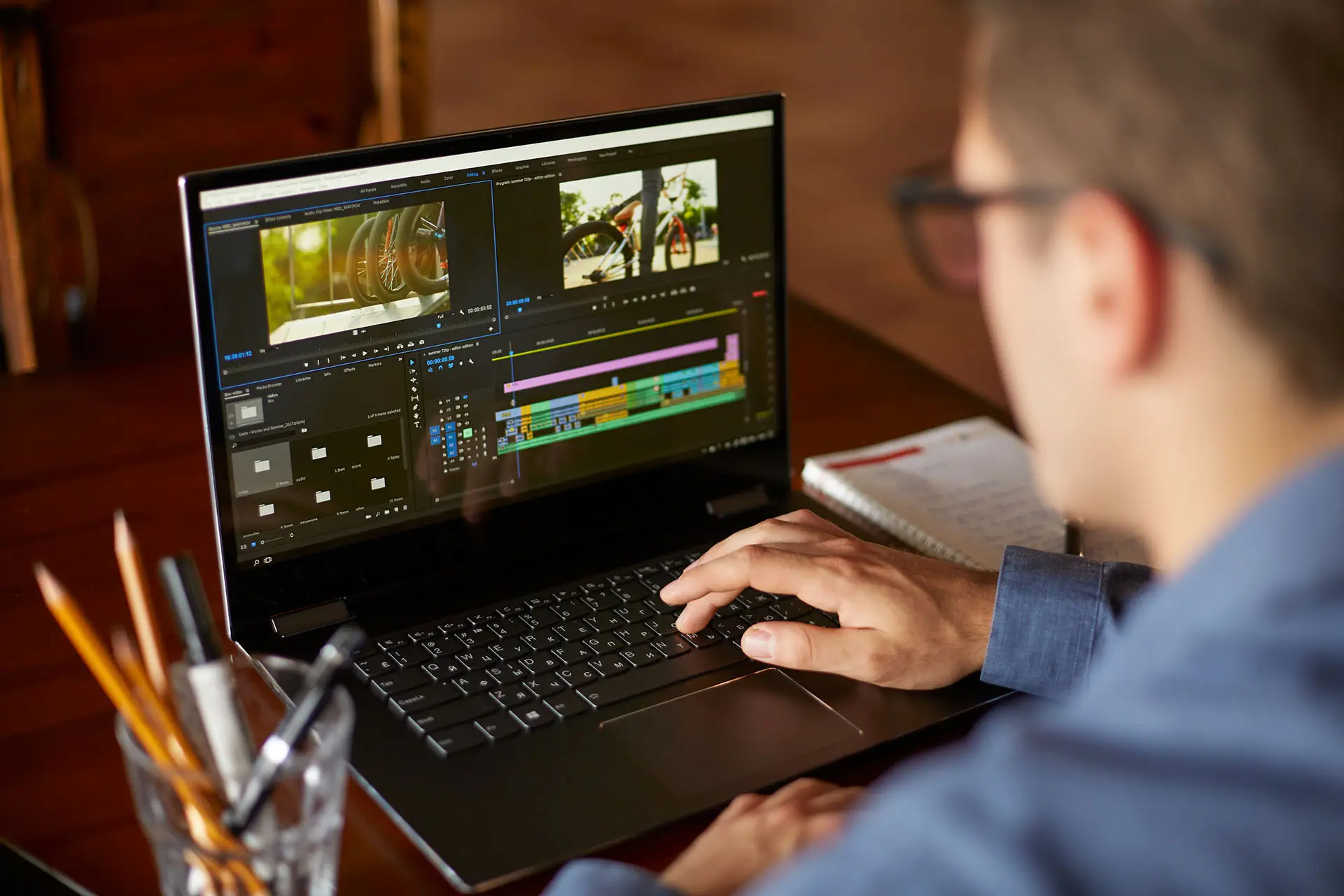 Top 5 Tips for Video Editing - this image shows a young man working at his laptop, on the screen we can see video editing software with the various settings