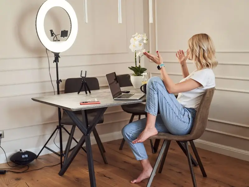 Video Marketing for Small Businesses - this image shows a lady sat at her desk talking into her smart phone which is held in a ring light - concept for Video Marketing for Small Businesses