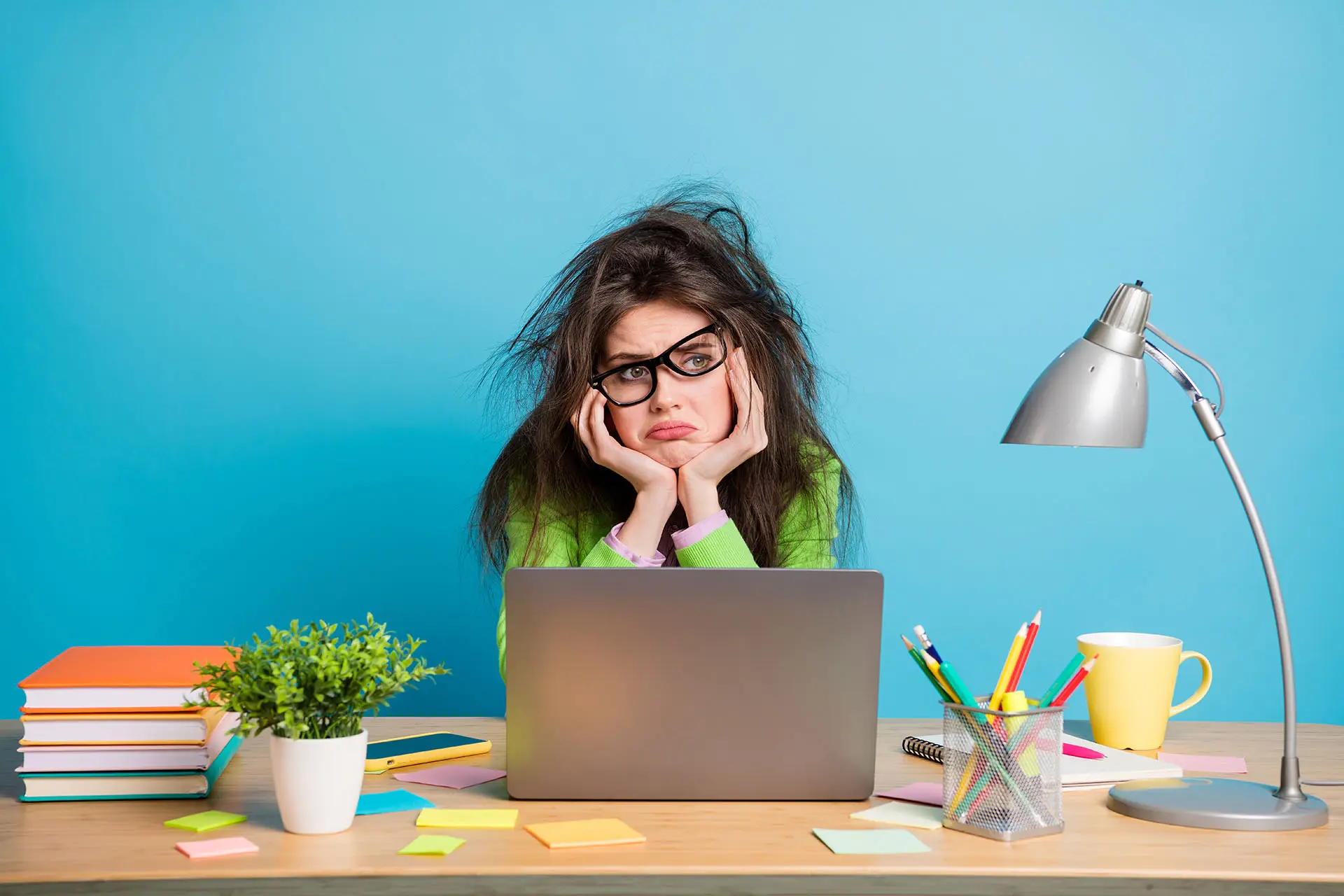 Website Jargon Explained this image shows a dishevelled lady sat at her lap top with her glasses askew. Concept for frustration understanding web terms