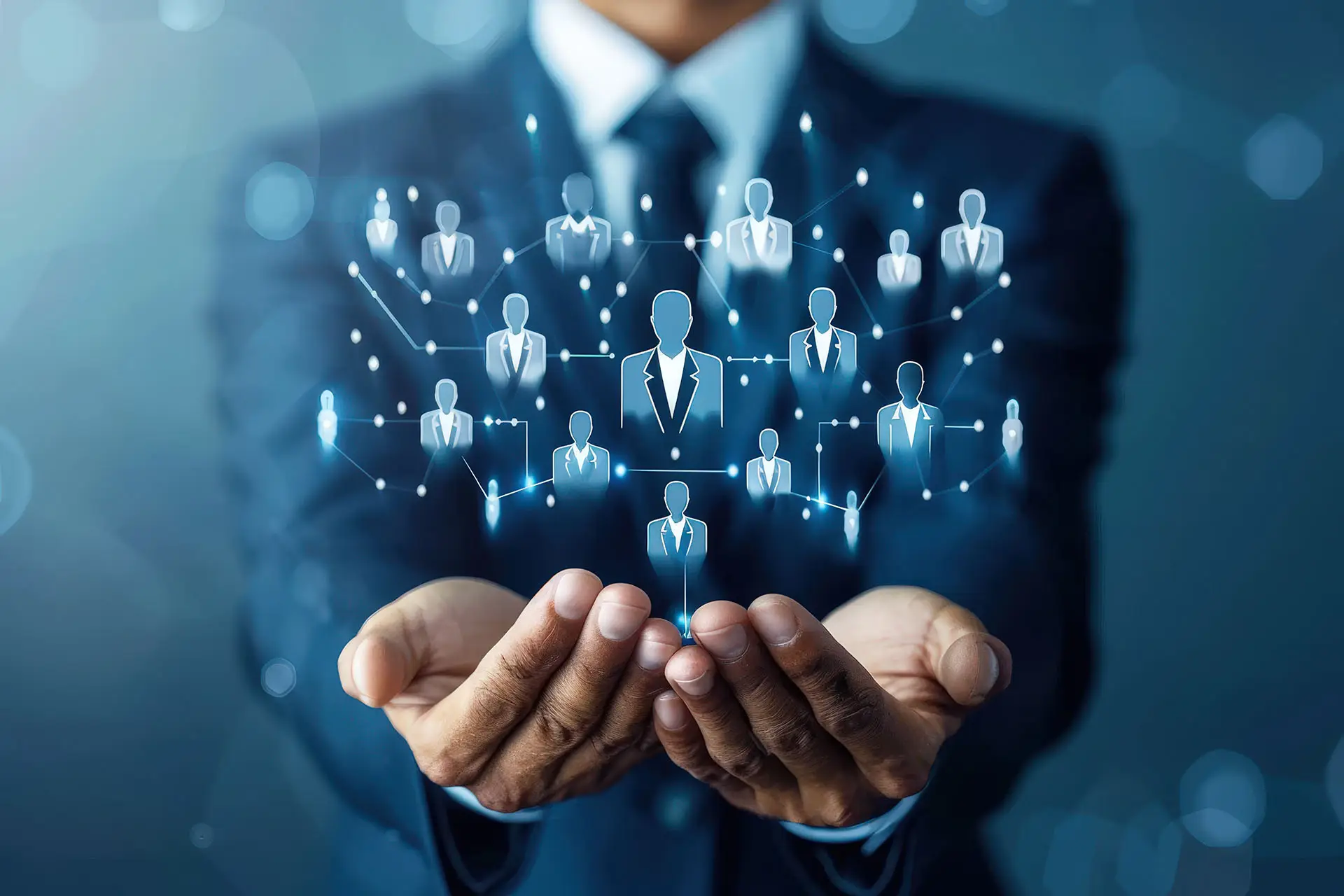 Why LinkedIn Adverts Are Worth A Look - this is a mainly blue image with a man in the foreground in a blue suit with his hands cupping a graphic of avatars that are all connected via digital lines - concept for business networking platform