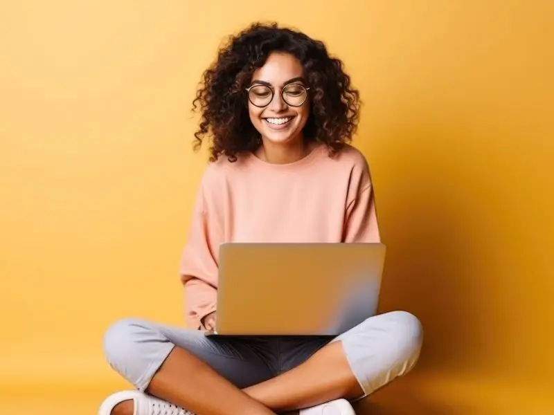 Why You Should Have Rules of Acceptance for Your Guest Blog - this image shows a bright yellow background with a lady sitting cross legged, writing at her laptop