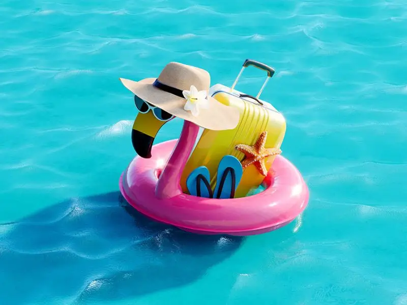 Why You Should Think Twice Before Posting Your Holiday Snaps! Image shows a turquoise blue pool with a pink flamingo inflatable wearing a sun hat with a yellow suitcase and flip flops