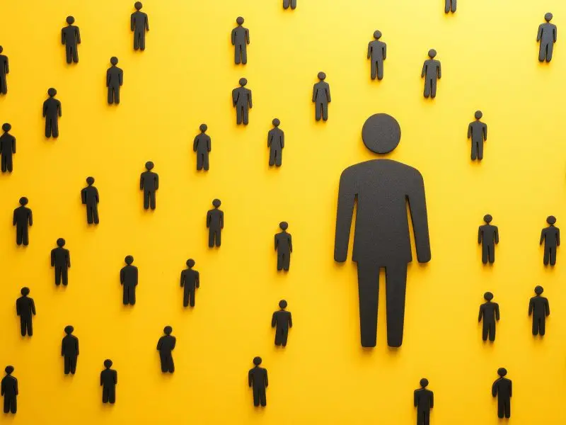 10 Ways to Make the Most of LinkedIn - this image shows a bright yellow background, with black people figures dotted all over the canvas with a larger figure in the centre - concept for networking through LinkedIn