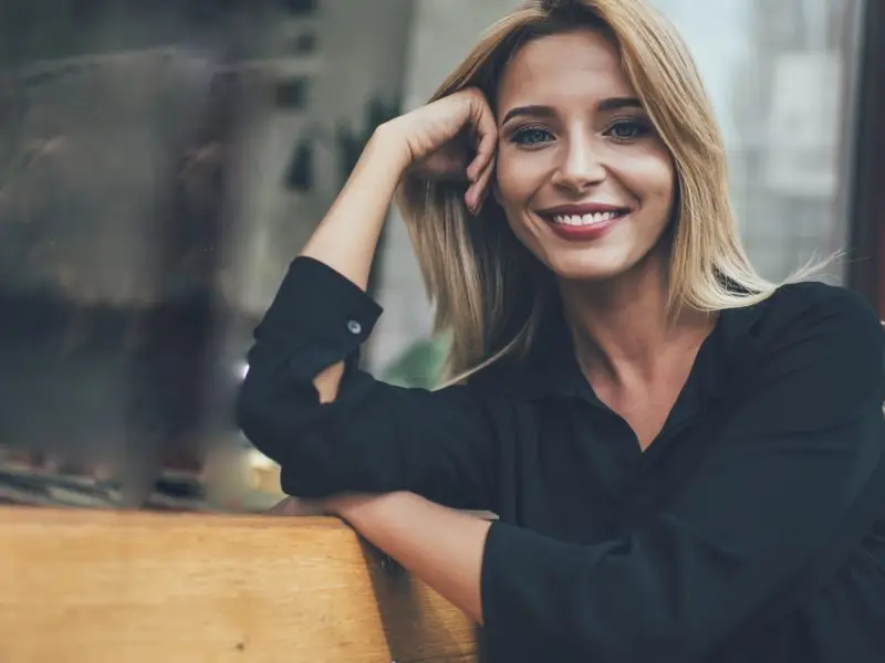 Stop The Scroll - this image shows a lady seated on a bench, she is smiling and relaxed and it feels like she is making eye contact with the viewer, an example of scroll stopping content as per the article