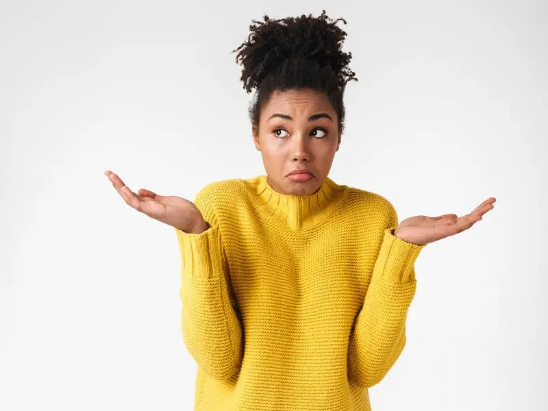 What Should Be Included On A Service Page? this image shows a white background with an attractive young lady in the foreground shrugging