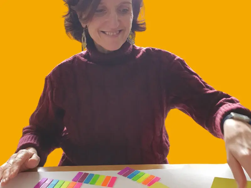 Working with Orchard Home Cleaning for Sustainable Business Development - this image shows Ann Brebner local business owner sat at a table with a variety of coloured sticky notes and a large sheet of paper just starting to map out processes