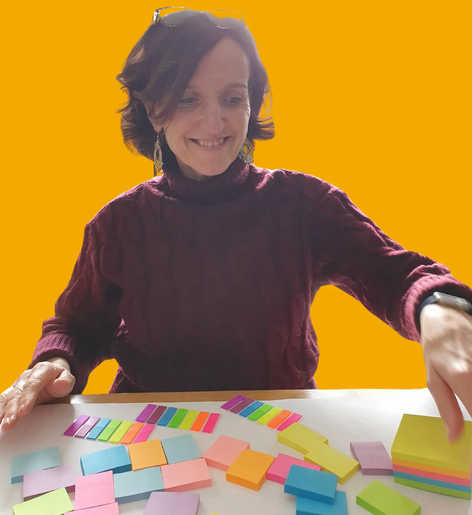 Working with Orchard Home Cleaning for Sustainable Business Development - this image shows Ann Brebner local business owner sat at a table with a variety of coloured sticky notes and a large sheet of paper just starting to map out processes