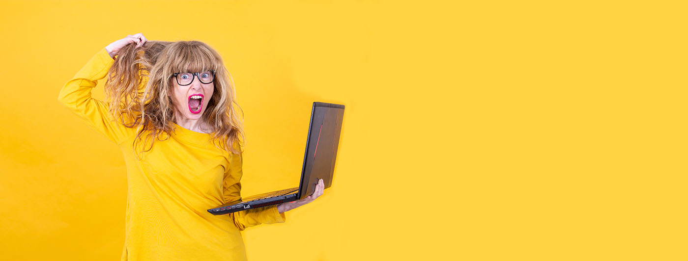 How to Clear Your Browser Cache - this image shows a bright yellow background with a blonde lady holding a laptop and pulling at her hair, her facial expression is frustrated and annoyed