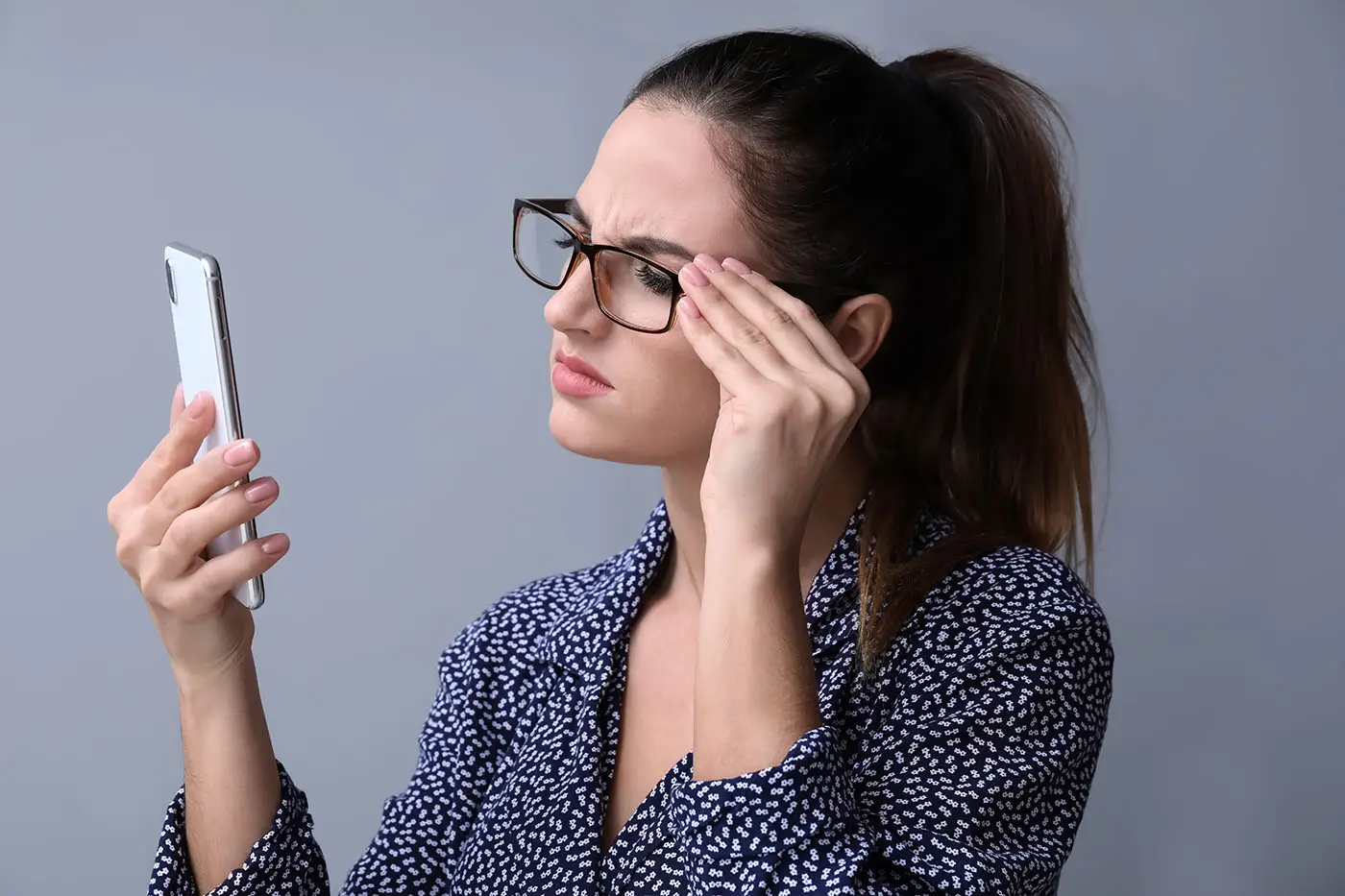 What Should Be Included in an Email Campaign? This image shows a lady wearing glasses trying to make out the words on her phone - concept for email accessibility